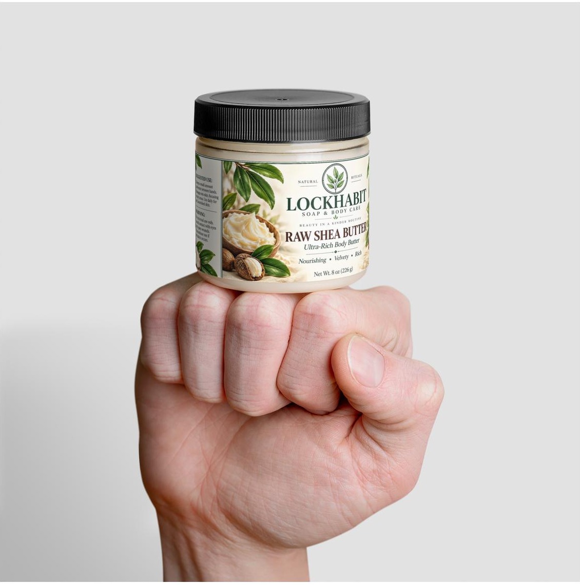 LOCKHABIT Raw Shea Butter jar held upright